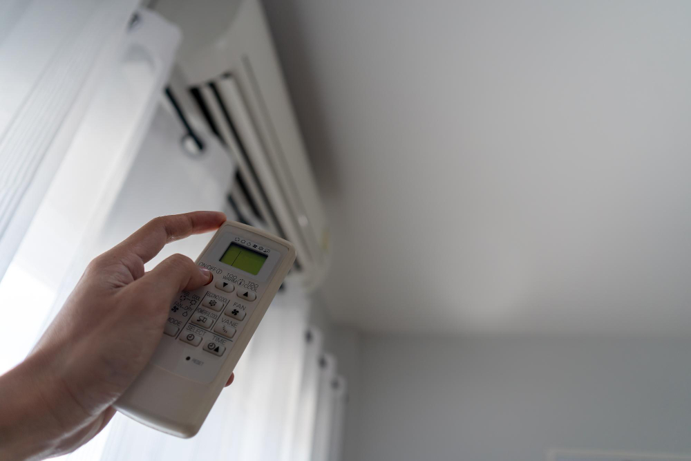 Consumo de ar-condicionado - pessoa verificando temperatura do ar-condicionado com o controle