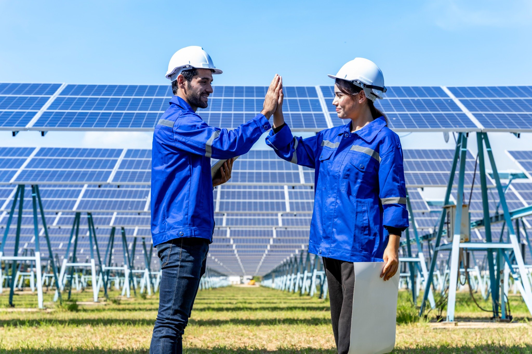 Engenheiros dando as mãos em usina solar.