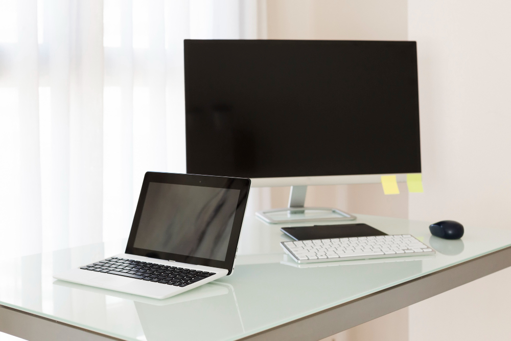 Computador ou notebook: mesa com desktop e notebook lado a lado